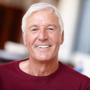 Elderly man with bright white teeth smiling