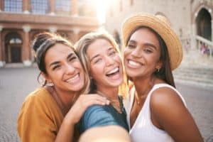 Three young smiling hipster women in summer clothes.