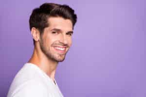 side view portrait of brown haired guy with bright smile