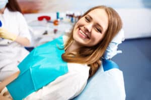Woman smiles in dentist chair before undergoing periodontal care