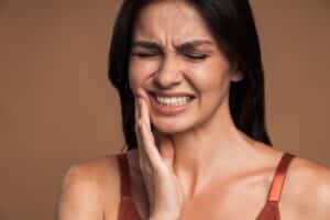 Woman with a cracked tooth holding her cheek